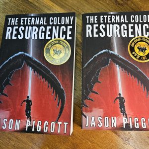 Two copies of Resurgence side-by-side on oak table